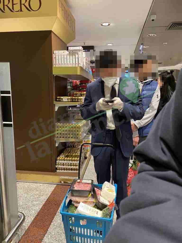 Persona de origen asiático con guantes y mascarillas por coronavirus en El Corte Ingles Hipercor