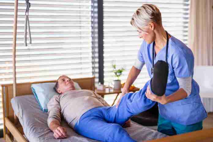 A healthcare worker and senior patient in hospital, physiotherapy concept. aumentan pacientes fisioterapia por covid 19