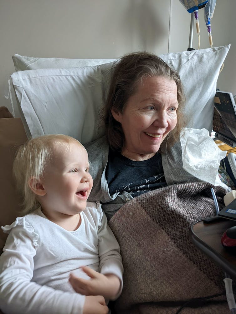 Woman in bed with laughing child