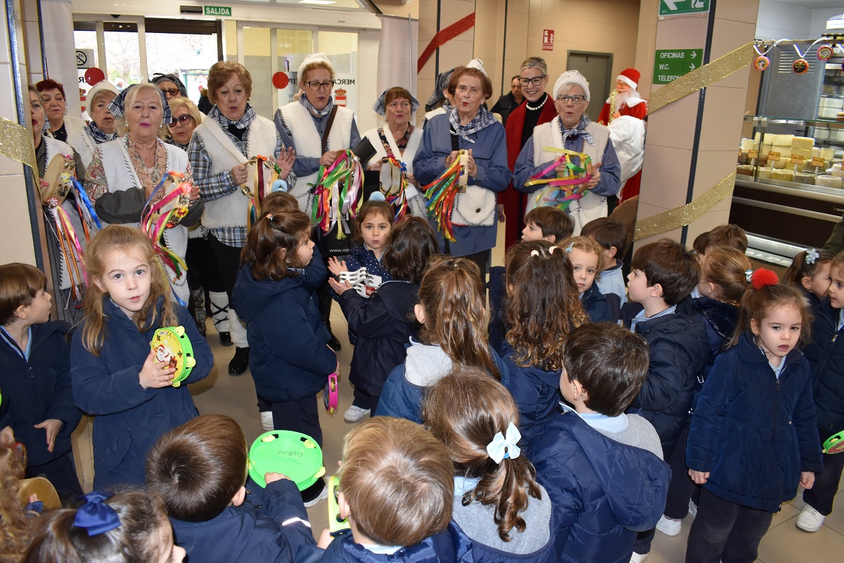 El Mercado Municipal vibra con la alegría navideña de los villancicos del Centro de Mayores 'Margarita Salas' y del colegio María Inmaculada 1