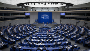 Hemiciclo del Parlamento Europeo durante una sesión extraordinaria con eurodiputados en sus escaños y la bandera de la Unión Europea al fondo