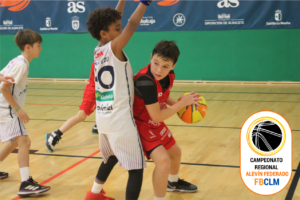 Jugadores alevines en un partido de baloncesto en pabellón cubierto