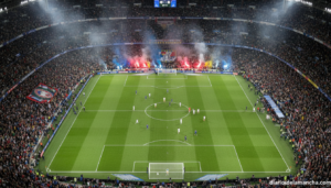 Estadio de fútbol lleno durante una semifinal de Champions League nocturna