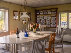 Comedor con mesa gustaviana, vajilla azul y blanca y expositor de platos en casa de campo sueca decoracion rústica