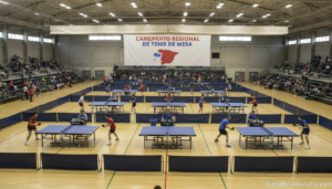 A table tennis regional championship inside a sports pavilion in Spain, ten competition tables set up in a large indoor sp...
