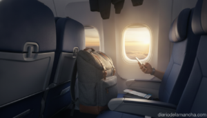 Mochila de cabina junto a ventanilla de avión con pasaporte y tarjeta de embarque