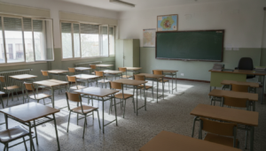 Fotografia periodistica realista de un aula de colegio publico espanol vacia en verano, pupitres ordenados, luz natural en...