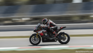 Dynamic realistic photo of a MotoGP-style motorcycle racer leaning hard into a fast corner on an asphalt racetrack, motion...