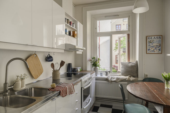 Vuelta al cole Cocina con suelo de ajedrez blanco y negro y mesa redonda de madera